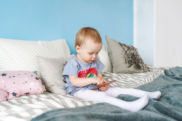 Naklejka premium Portrait of a cute baby girl with a mobile phone