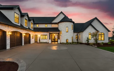 Foto op Canvas Stunning Luxury Home Exterior at Sunset with Colorful Sky and Expansive Driveway. This Mansion has Three Garages, Turret Style Tower, and Two Floors  © bmak