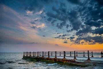 Tuinposter Old pier on background of sunset on beach © alexytrener