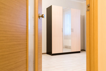 Ajar door to room with a cupboard