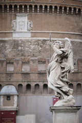 Fototapeta na wymiar Angel with a spear statue on the Ponte Sant Angelo bridge in Rome, Italy