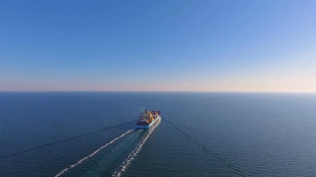 Aerial view of container ship floats in the open ocean after loading in the port of China at full speed. 4K.