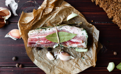 Baked Ham with bread and spices on a dark table