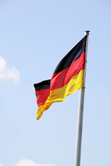 Swinging German flag against blue sky
