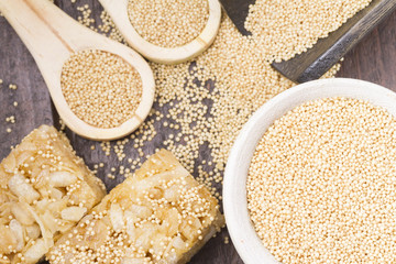 Amaranth seeds and energy bars on wood