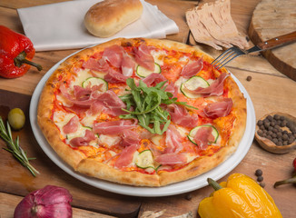 the pizza on the table next bread and vegetables