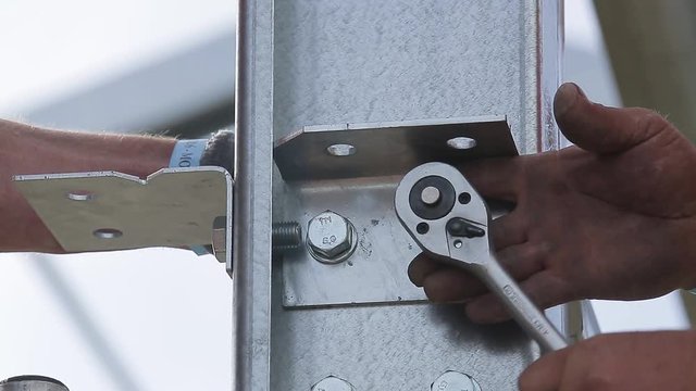 Przykręcanie metalowego elementu kluczem grzechotkowym
