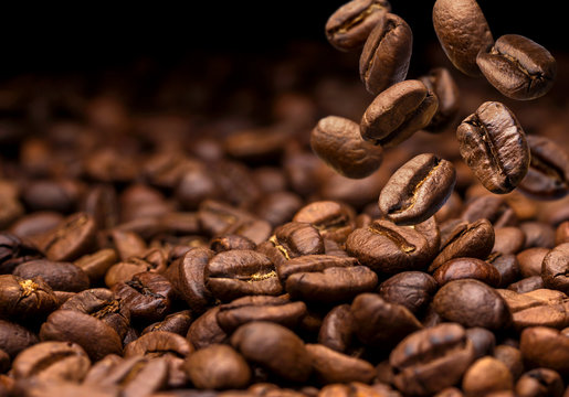 Falling coffee beans. Dark background with copy space, close-up