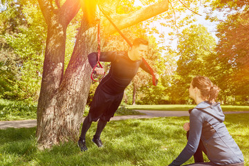 Schlingentraining mit Personal Trainer im Park