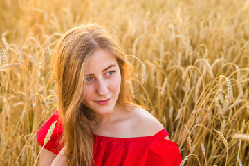 Beautiful lady in wheat field at sunset