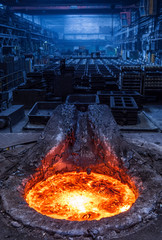Burning cast iron in induction furnace, molds in background