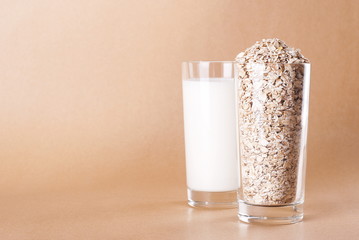 Oatmeal and milk in glasses on a beige background