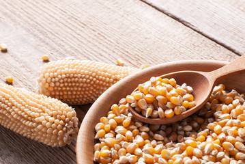 Raw corn in a wooden spoon