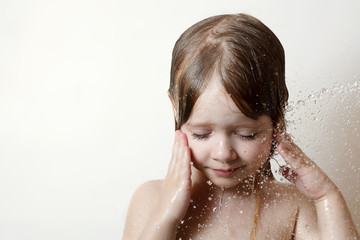 the little girl in the bathroom under running water, beautiful drops the person