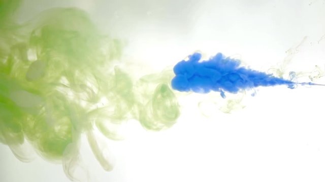 Blue ink in colored water abstract background texture slow motion