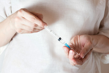 the woman is gaining in a syringe medication from the vial