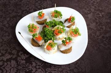 Fish canapes on a white plate