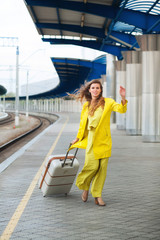 Young woman with suitcase walking for her train railway station