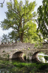 Fototapeta na wymiar Ancient bridje on the crystalline wather in the Garden of Ninfa in the province of Latina, Italy, Europe