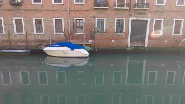 White motor boat, canal in Venice, Italy. Reflection in water
