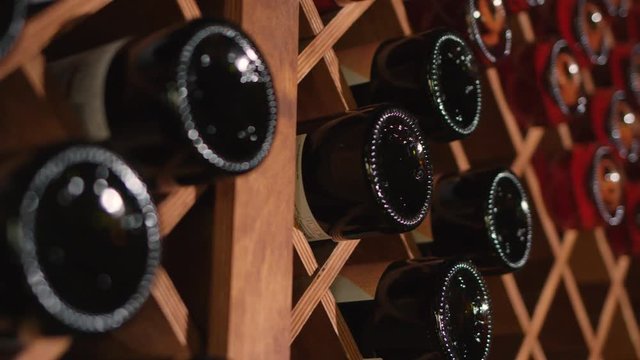 Attractive sommelier coming to the room with wine and choosing the best one for the clients. Slow motion.
