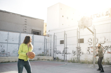 Two friends playing basketball together