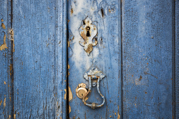 ancient door knocker and locks of an ancient blue wooden door