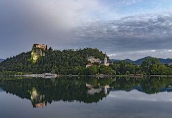 Fototapeta na wymiar Bled castle at sunrise with mountain