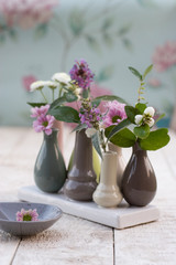 Kleine Vasen mit Blueten und Schneebeeren