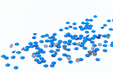 Precious sparkling rhinestones Capri blue colors on a white background.