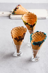Chocolate dipped ice cream cones with sprinkles decorations