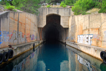 Concrete bunker shelter for submarines in adriatic sea. Beautifull clear blue water sea.