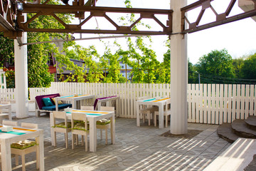 Beautiful interior of the outdoor restaurant of white wood with sun shining