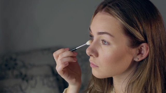 Make-up artist applying eye shadow with brush, close up.
