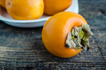 Delicious fresh persimmon fruit on wooden table