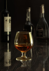 Glass with white, red wine and cognac or whisky on mirror table. Celebrities composition. selective focus