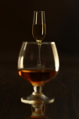 Glass with white, red wine and cognac or whisky on mirror table. Celebrities composition. selective focus