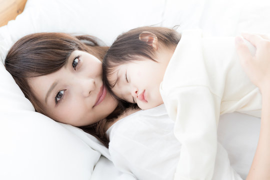 asian mother and baby on bed