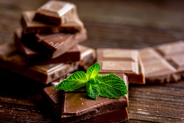 black chocolate design with mint on wooden background
