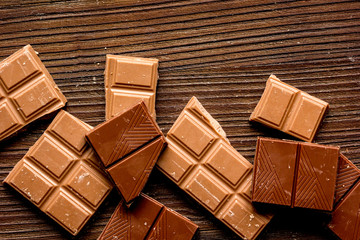 chopped chocolate pieces for dessert wooden desk background top view
