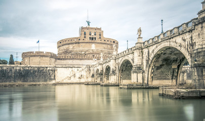 Ponte Sant'Angelo bridge crossing the river Tiber and Castel Sant'Angelo (AD 135), mausoleum of Hadrian, now a museum and art gallery illuminated at night in the heart of Rome.