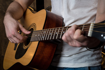 Playing guitar. Acoustic guitar in the hands of the guitarist. Horizontal frame