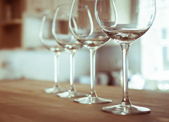 Wine tasting. Row of wine glasses on wooden bar table. 