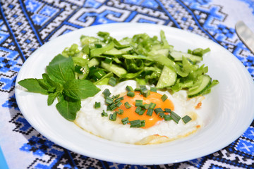 Appetizing scrambled eggs with cabbage salad on a white plate