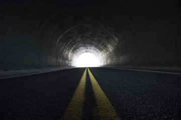 Looking down a tunnel with a white light at the end 