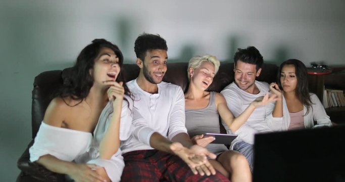 People Group Sitting On Couch Using Tablet Computer Watching TV Program Talking, Young Friends Communication Slow Motion 60