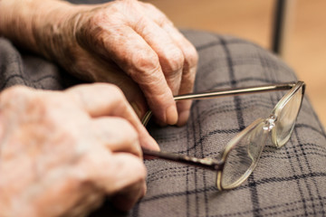 Grandmother hands hold glasses  