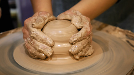 Potter is making clay pot bowl or vase ceramics porcelain on the potter's wheel. Creating pottery art and handicraft modelling creation.