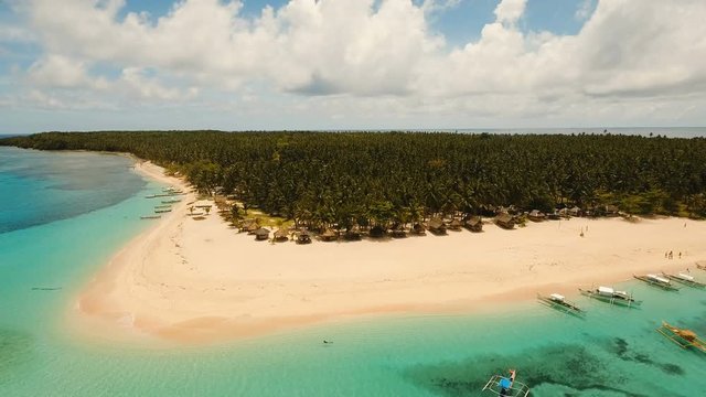 Aerial view of beautiful tropical island Daco with white sand beach. View of a nice tropical beach from the air. Beautiful sky, sea, resort. Seascape: Ocean and beautiful beach paradise. Philippines