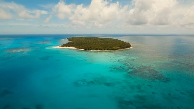 Aerial view of beautiful tropical island Daco with white sand beach. View of a nice tropical beach from the air. Beautiful sky, sea, resort. Seascape: Ocean and beautiful beach paradise. Philippines